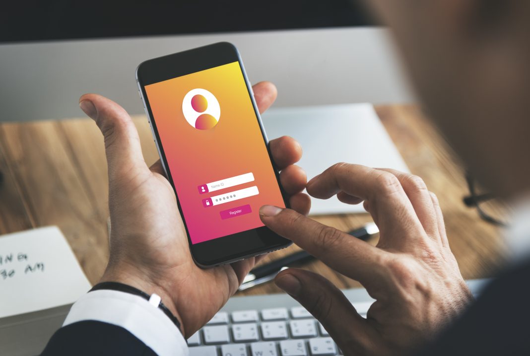 mAadhaar App Retired: How To Move To The New Aadhaar App Safely Person using smartphone showing Aadhaar app interface for digital identity verification